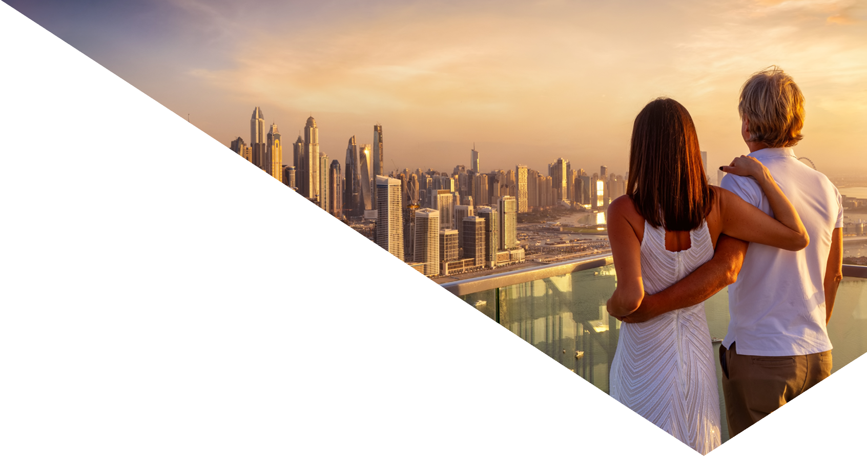 A hugging couple enjoys the panoramic sunset view of the Dubai Marina, UAE