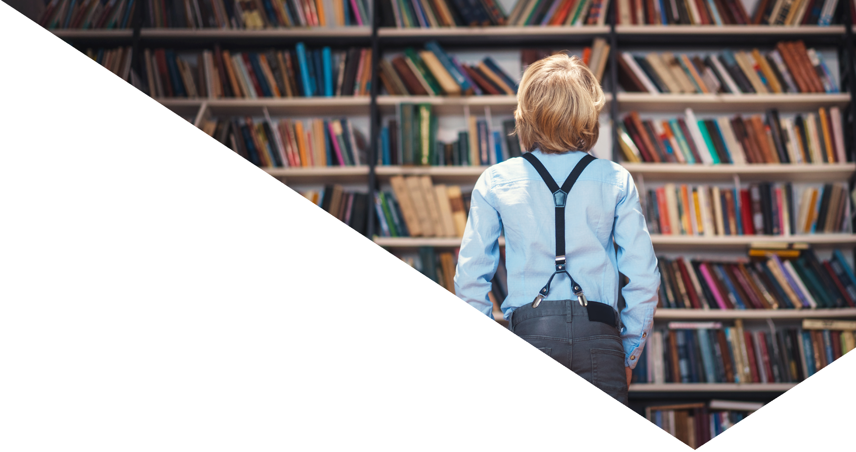 little boy looking at books in the library