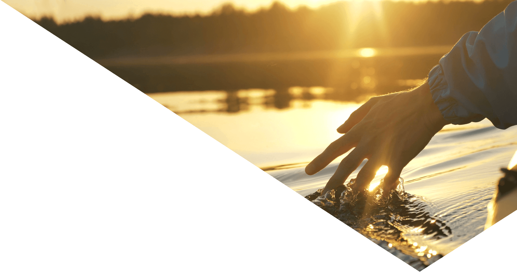 hand touching water at sunrise