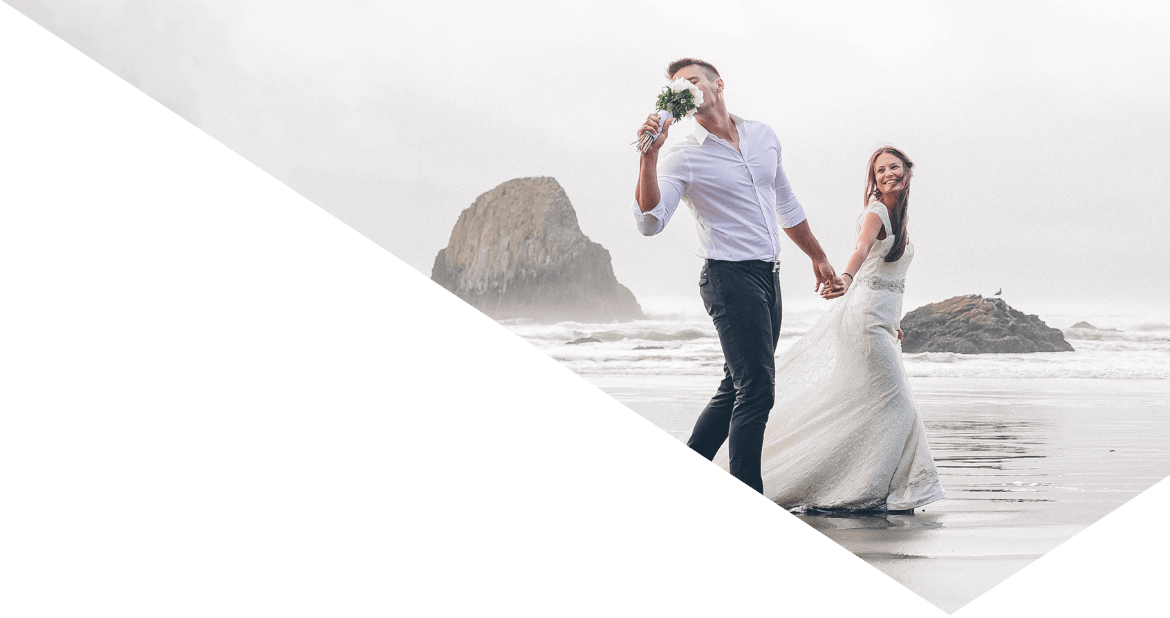 Happy bride and groom walk by the beach